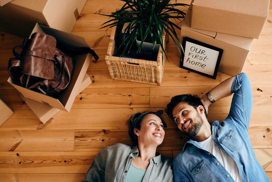 familie-29-umzug-haus-wohnung-kartons-04 Paar liegt auf Boden